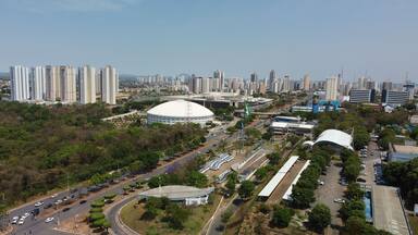 Un paisaje urbano con rascacielos, un estadio grande y una zona verde bien cuidada.
