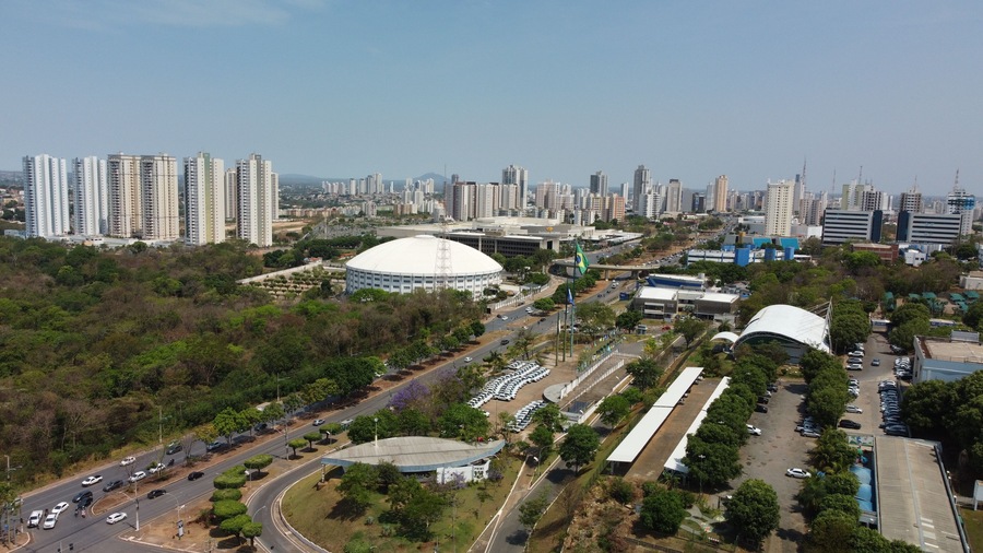A cityscape with high-rise buildings, a large stadium, and a well-maintained park area.