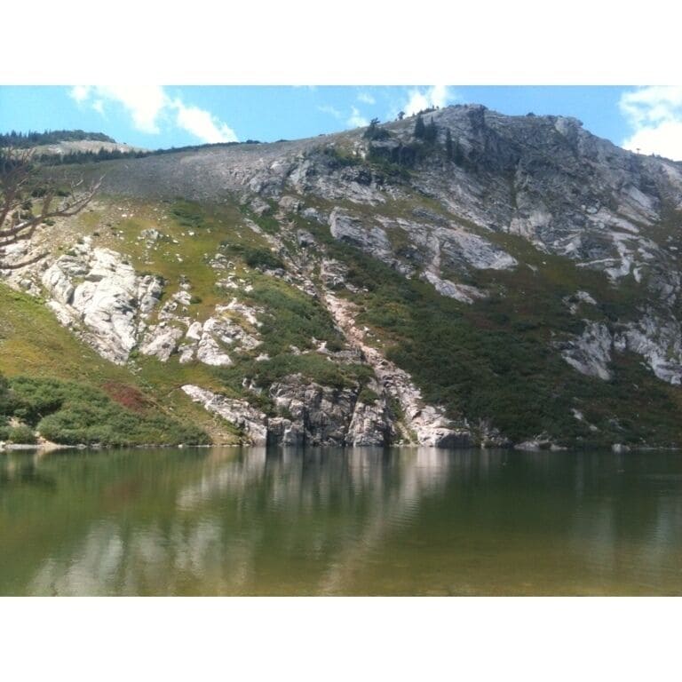 A mountainous landscape with a lake reflecting the rocky terrain.