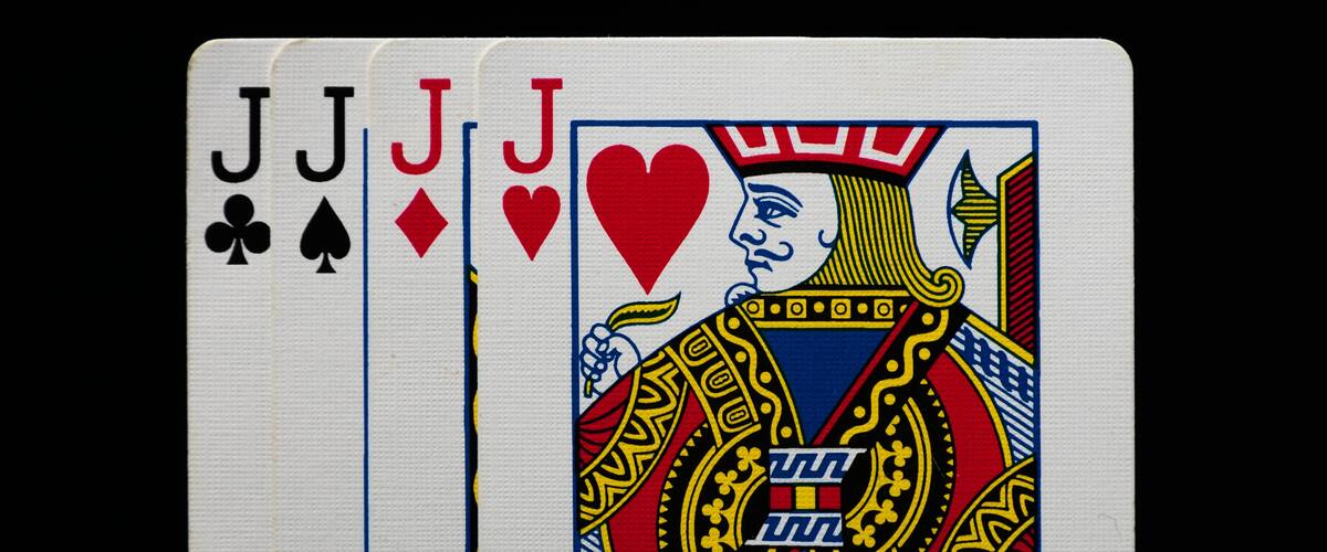 Set of four Jacks from a deck of playing cards, arranged in a row. A classic card combination symbolizing strategy, luck, and the excitement of card games.