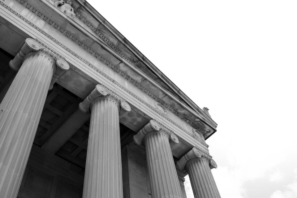 Un edificio clásico con grandes columnas y detalles tallados.