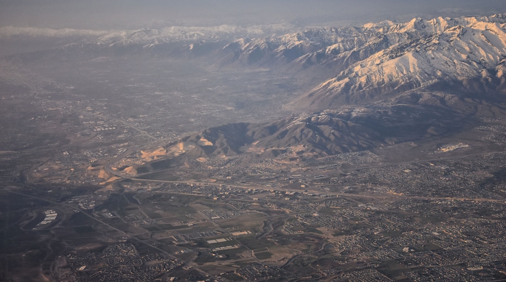 Aerial view from airplane of the Wasatch Front Rocky Mountain Range with snow capped peaks in winter including urban cities of Provo, Farmington Bountiful, Orem and Salt Lake City. Utah. United States