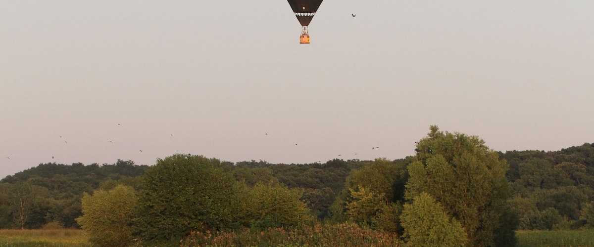 Hot Air Balloon Flies Above Placid Pond