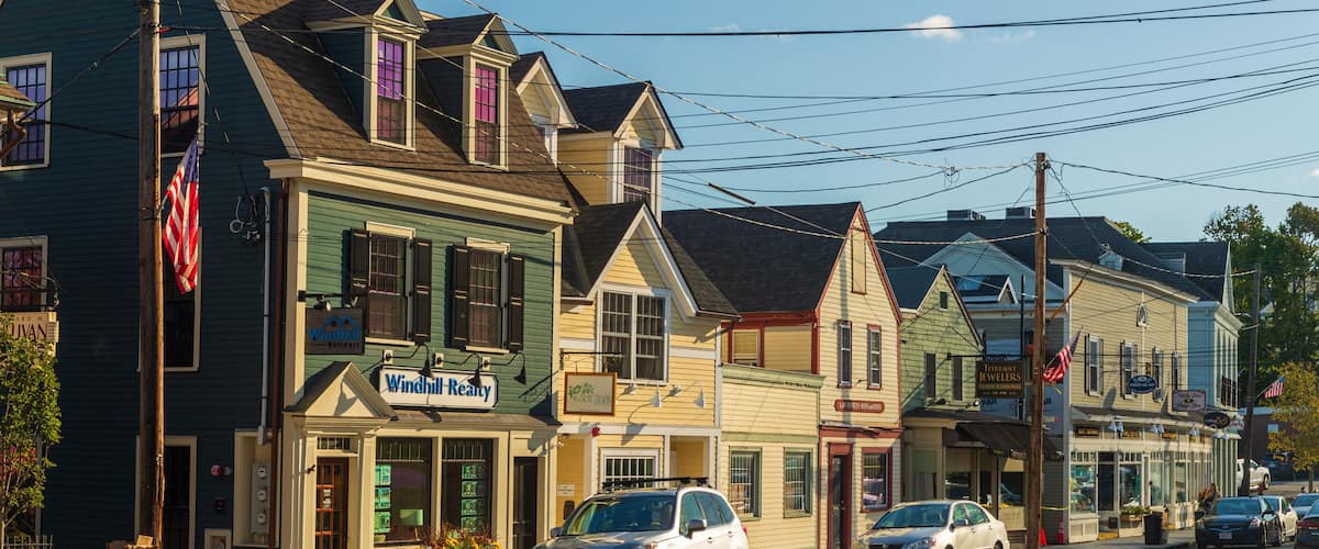 A street lined with historic buildings, including a Windhill Realty office and a jewelry store.