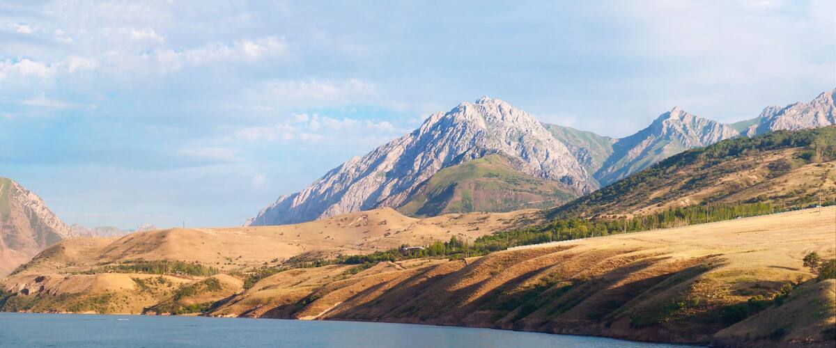 A mountainous landscape with a lake in the foreground and a village on the left.