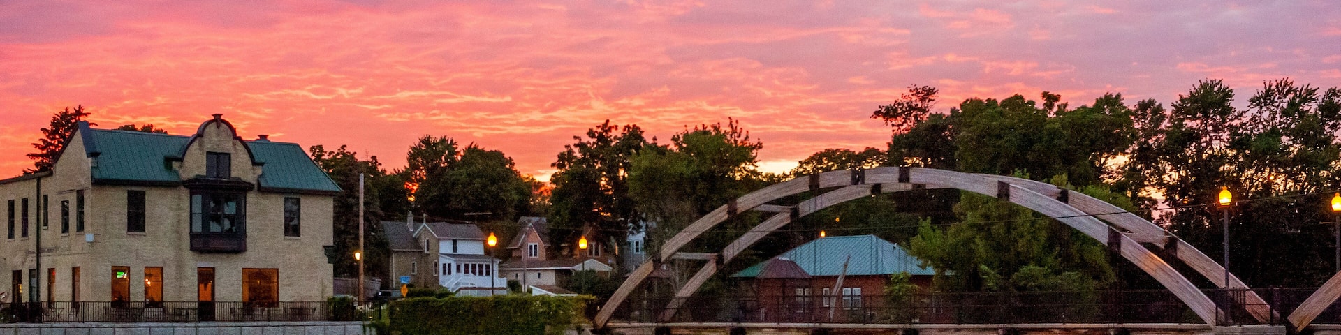 A very colorful sunset over Jefferson, Wisconsin reflected in the Rock River with the arched walk bridge.