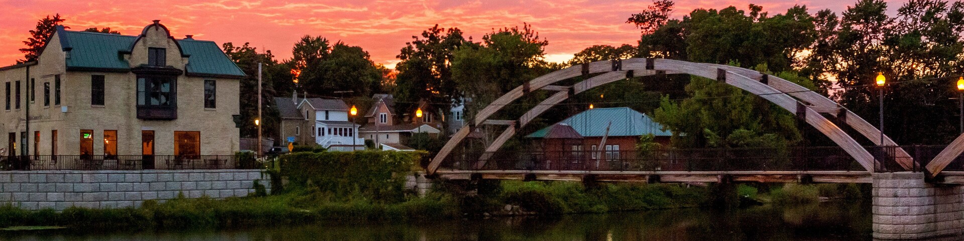A very colorful sunset over Jefferson, Wisconsin reflected in the Rock River with the arched walk bridge.