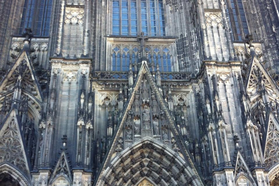 Eine gotische Kathedrale mit aufwendigen Steinschnitzereien, spitzbogigen Fenstern und großen Buntglasfenstern.