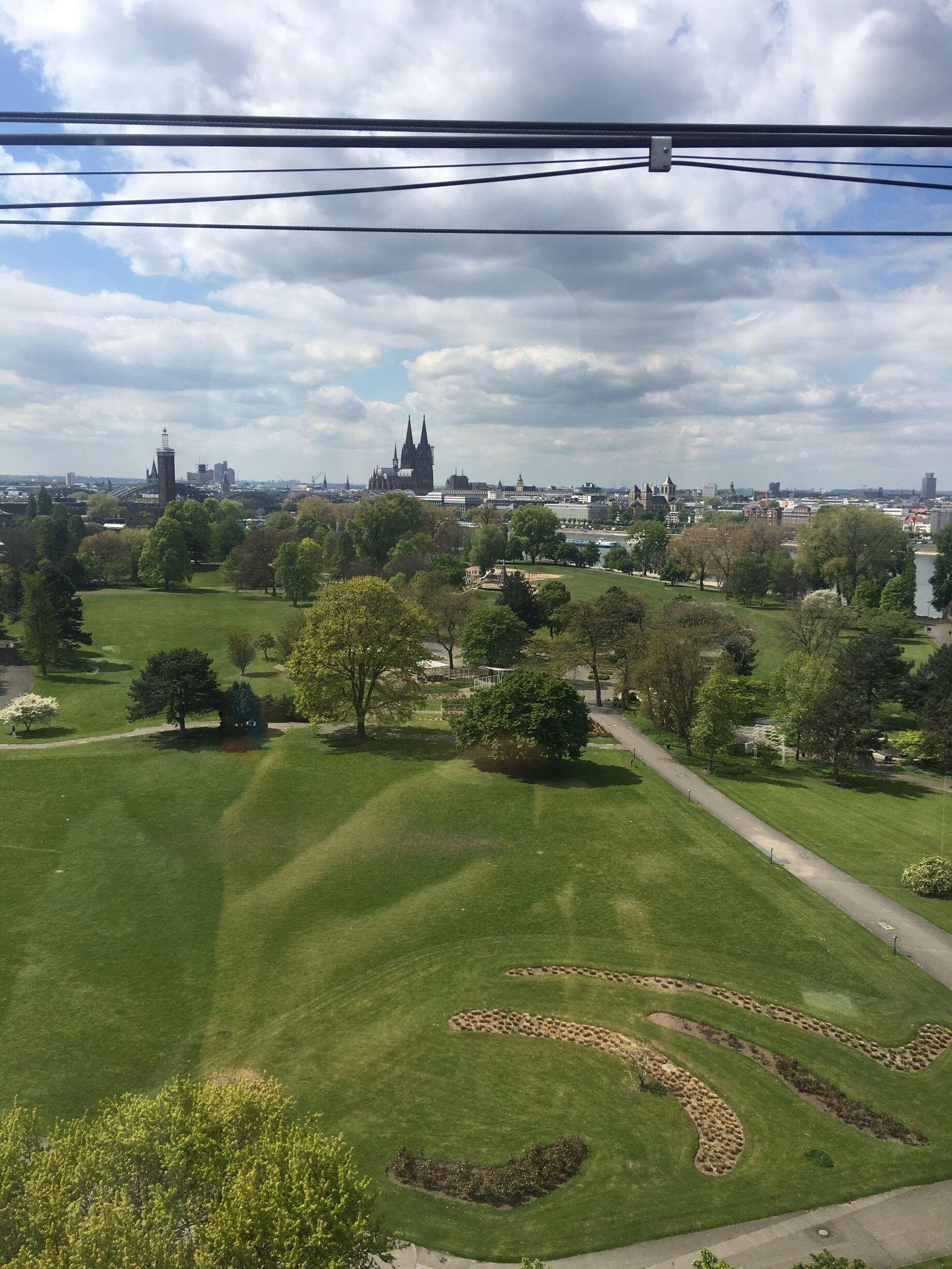 You see the Cologne cathedral in the background and the Rheinpark in the front, a local recreation area beside the river Rhine.