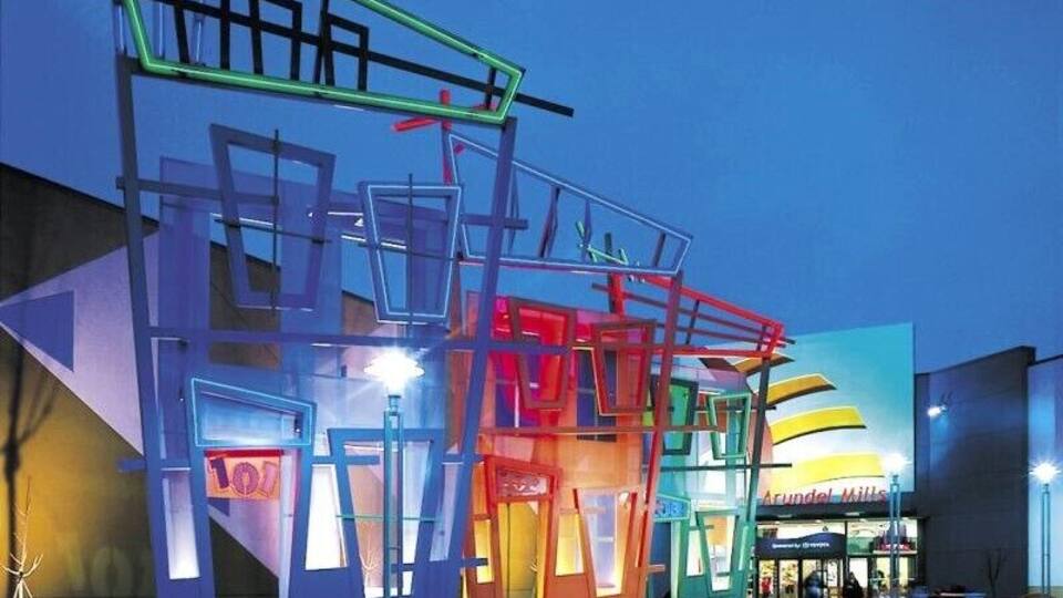 A modern building with colorful neon lights and a prominent sign.