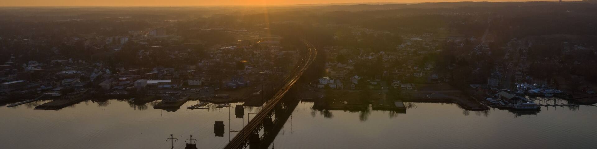 Aerial view of the bridge over the serene water reflecting the golden hues of the setting sun, Perryville, Maryland, United States of America.