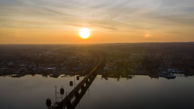 Aerial view of the bridge over the serene water reflecting the golden hues of the setting sun, Perryville, Maryland, United States of America.