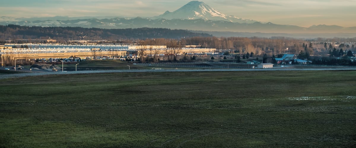 Mount Rainier rises above warehouses in Kent, Washington.