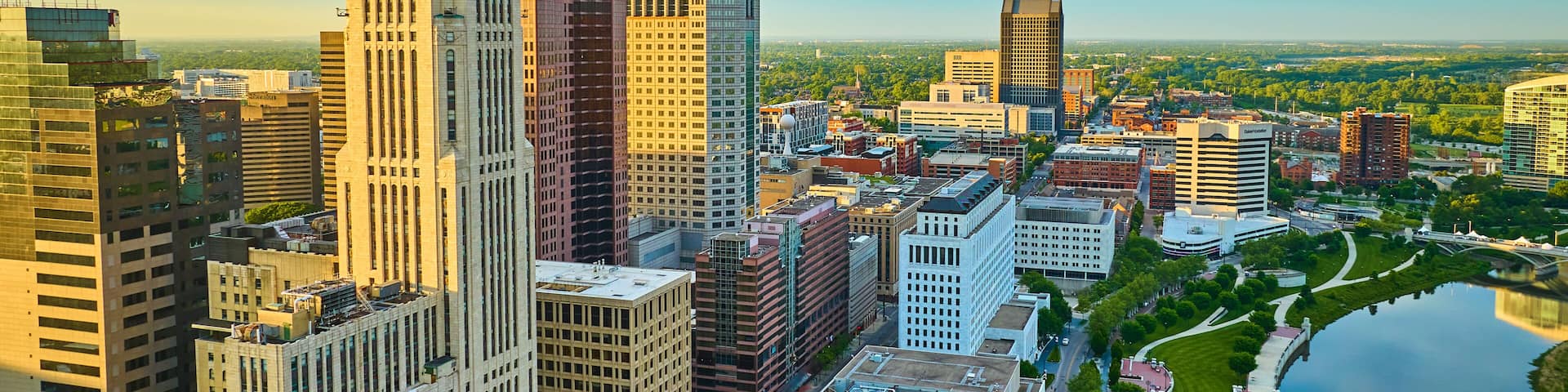 A cityscape with a mix of modern and historic buildings, a river, and a park.