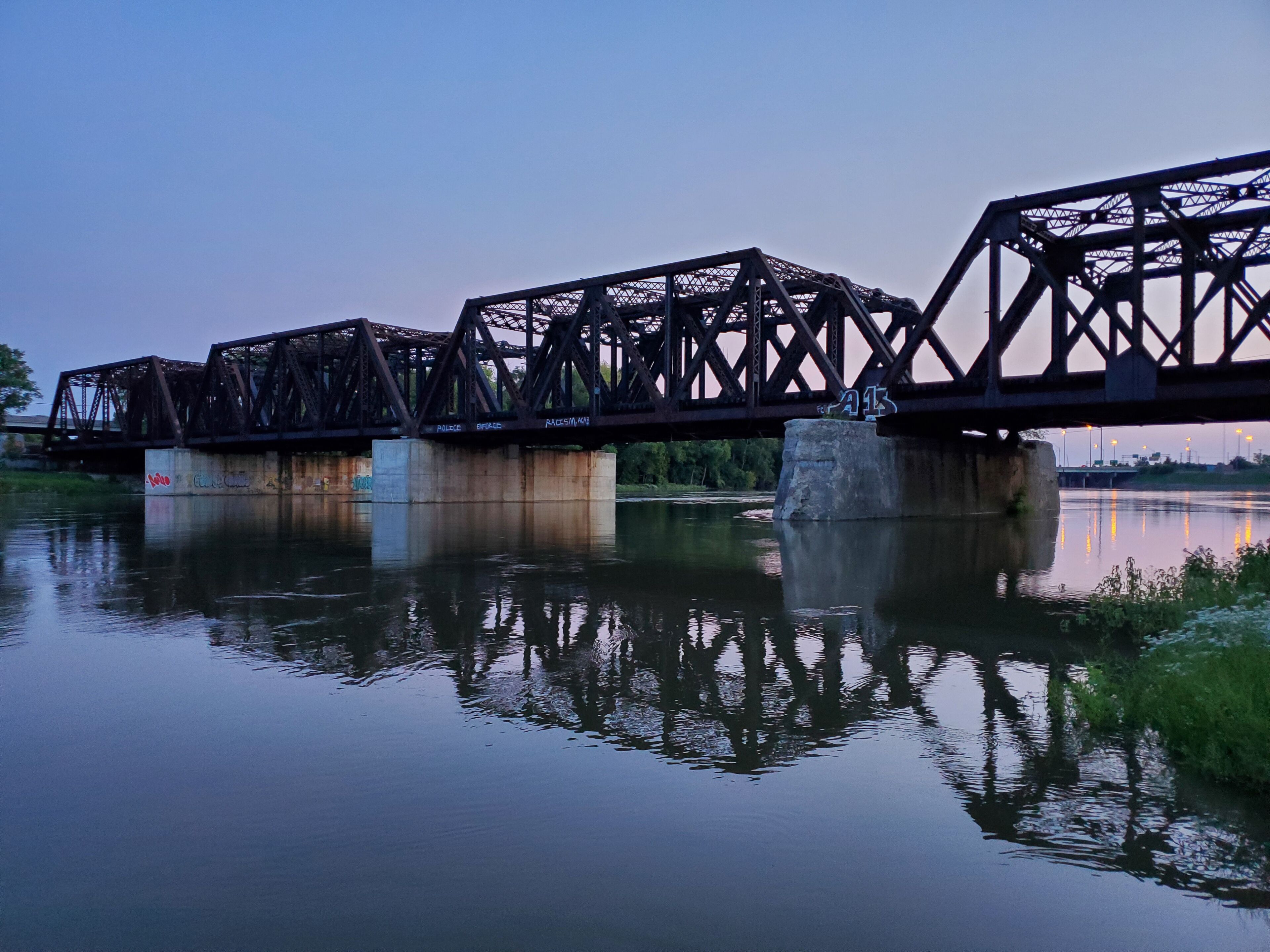 A metal train bridge over Scioto River in Columbus, Ohio during dusk