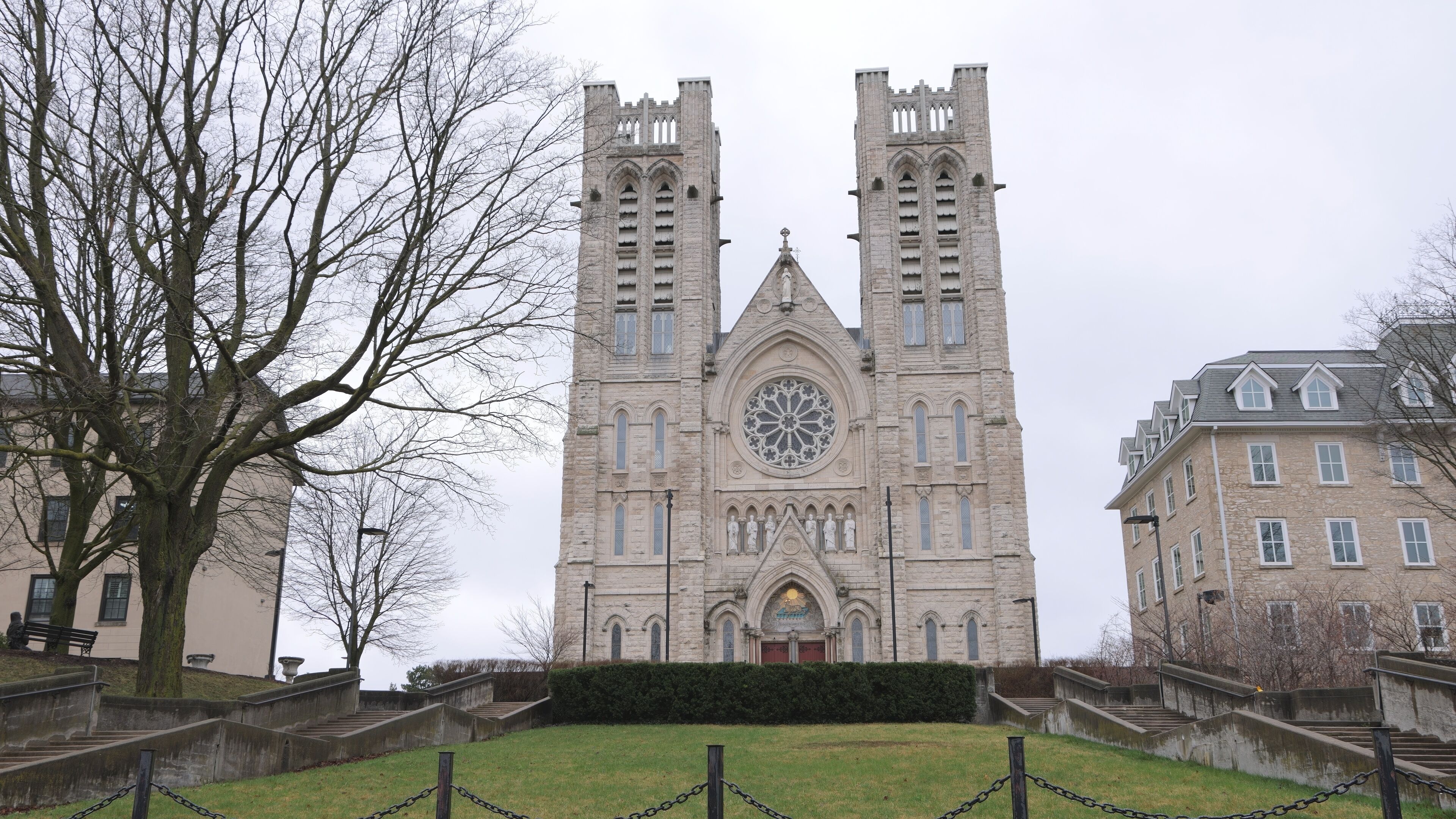 A large stone church with twin towers and a large circular window.