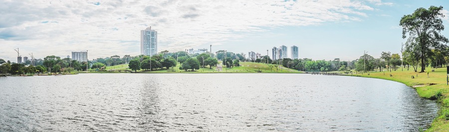 Panoramic view of the lake of a park on a beautiful sunny day. The water of the lake with some buildings on background and nature around. Photo at Campo Grande MS, Brasil.