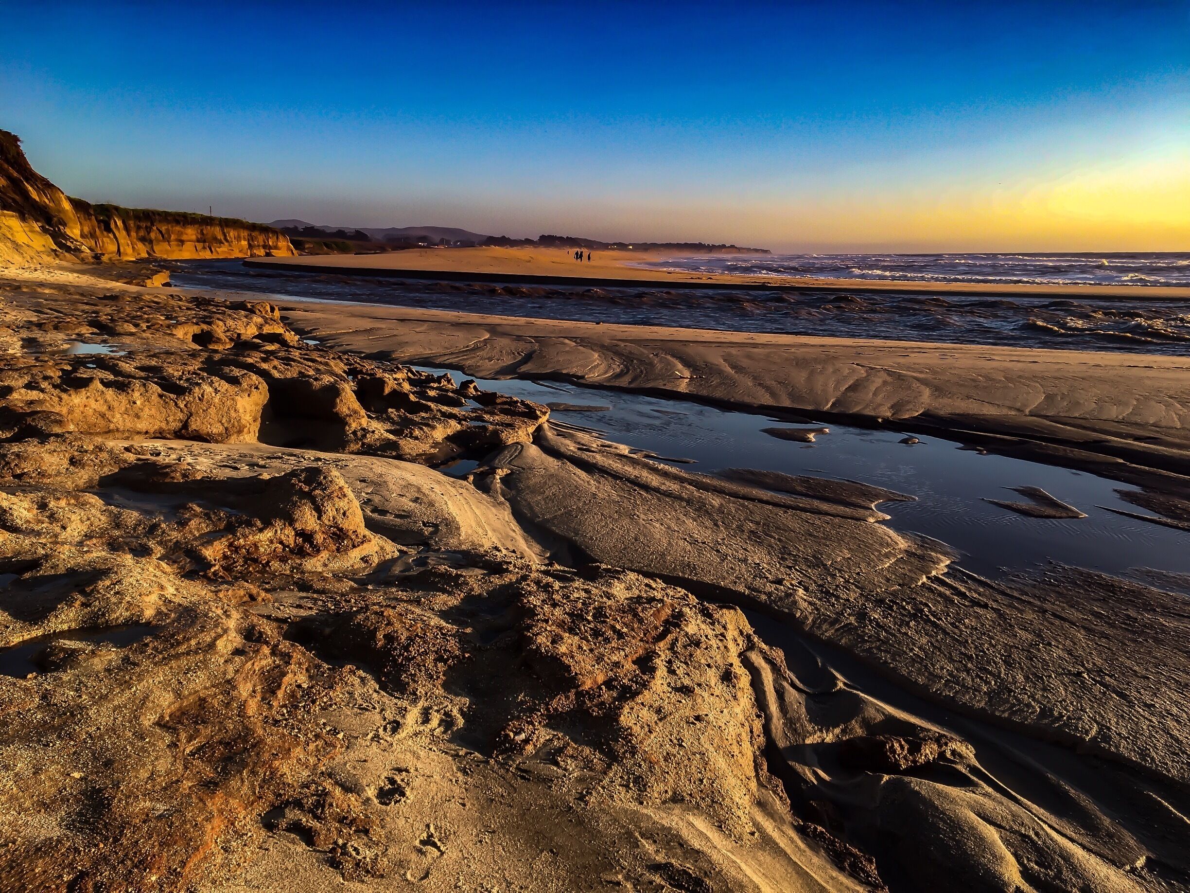 A rocky beach with waves crashing onto the shore.