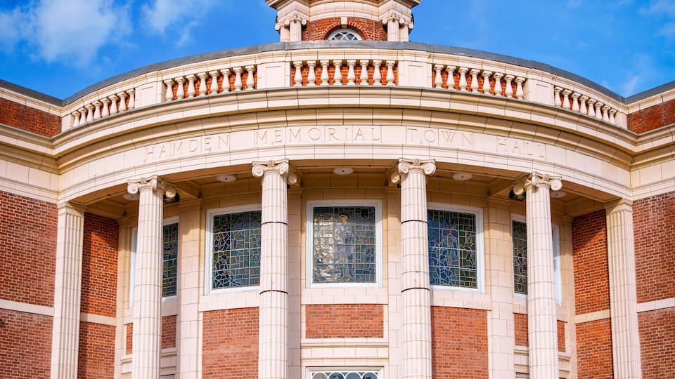 A historic building with a clock tower, large columns, and a dome.