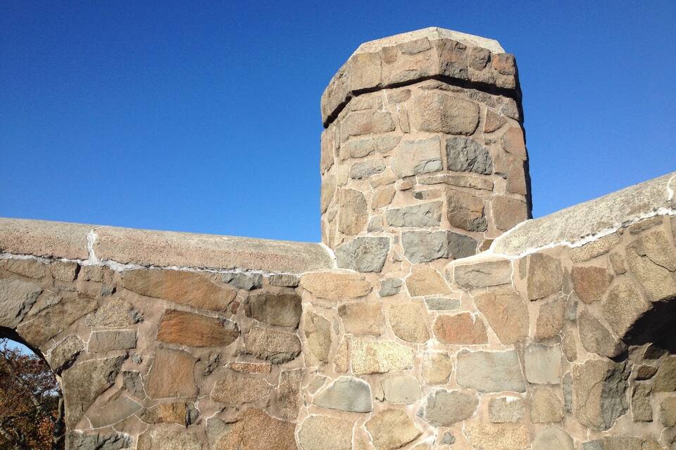 Uma estrutura de pedra com o topo arredondado e a base plana.