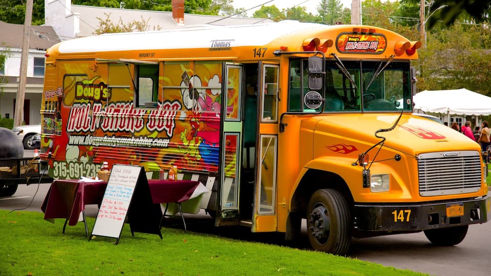 A yellow food truck with a colorful advertisement for 'Doug's BBQ'.