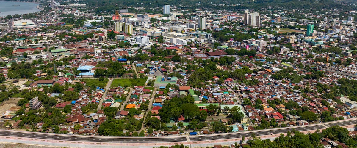 Cagayan de Oro with highway and modern buildings under blue sky and clouds. Northern Mindanao, Philippines.