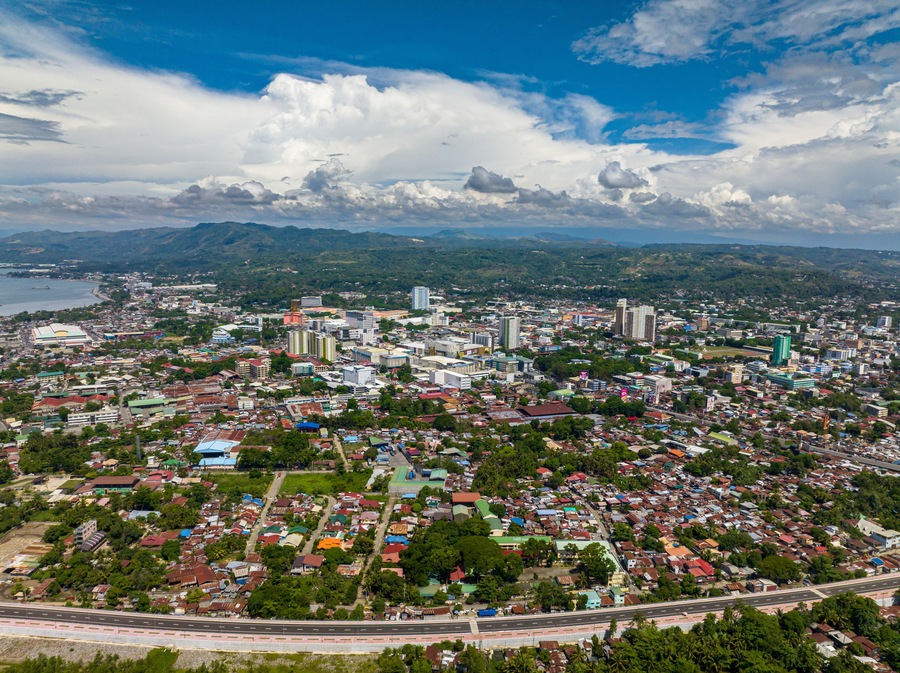 Cagayan de Oro with highway and modern buildings under blue sky and clouds. Northern Mindanao, Philippines.