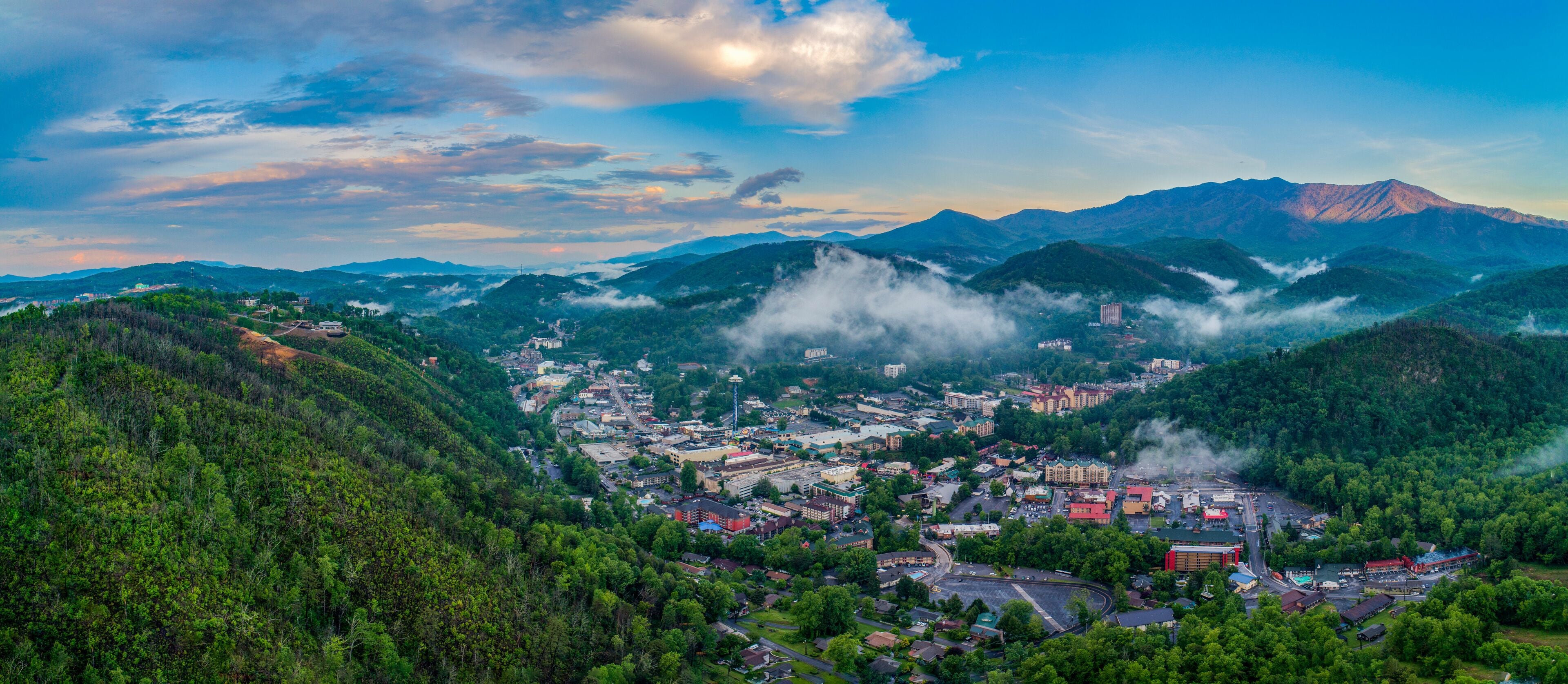 A town nestled in a valley surrounded by mountains, with visible buildings and roads.
