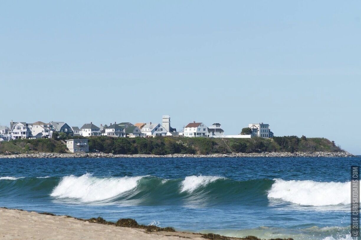 A coastal town with white houses and a lighthouse.