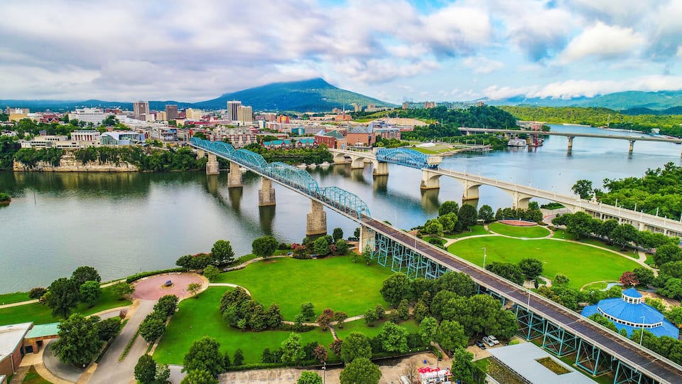 A cityscape with a river, a bridge, and a mountain in the background.