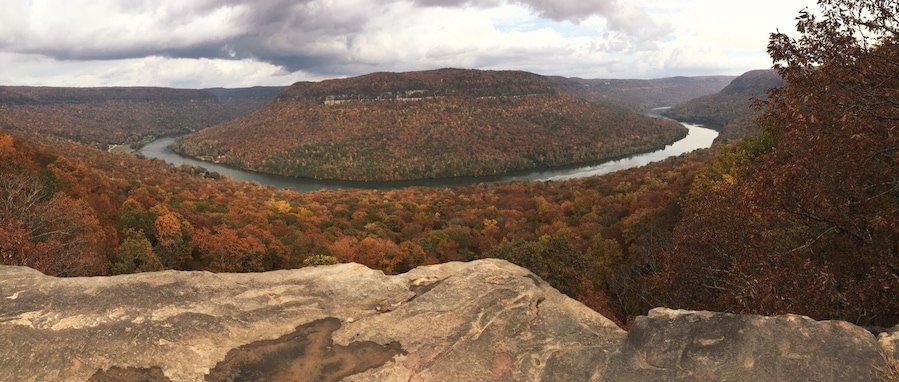 A river winding through a forested valley with autumn foliage.