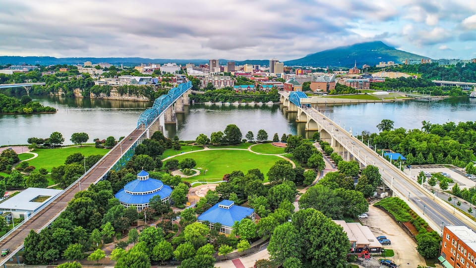 A cityscape with a river, a bridge, and a mountain in the background.