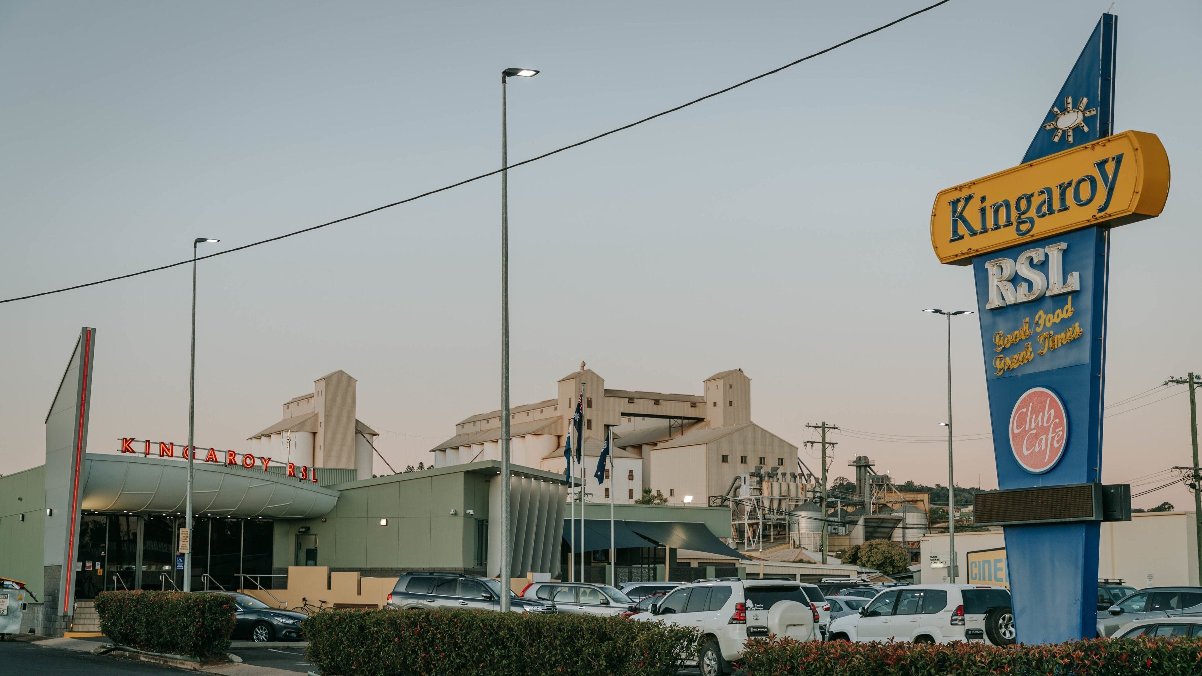A parking lot with cars, a building with 'Kingaroy RSL' signage, and a 'Club Cafe' sign.
