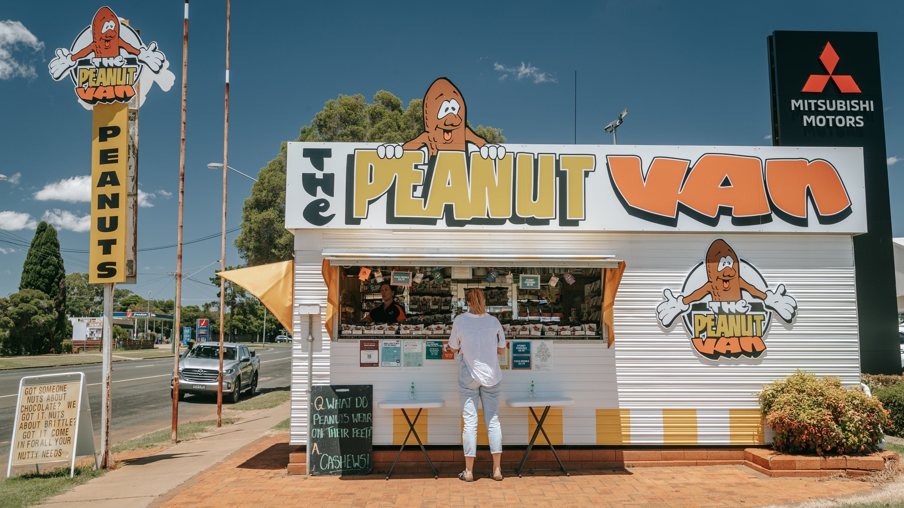 A roadside snack stand named "The Peanut Van" with a cartoon peanut character logo.