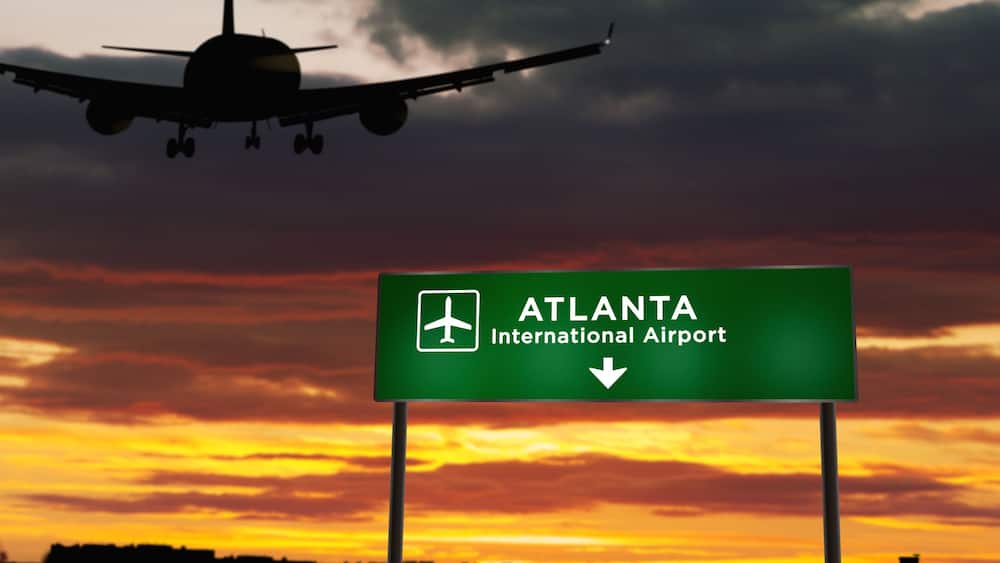 Ein Flugzeug nähert sich dem internationalen Flughafen Atlanta, mit einem Sonnenuntergang im Hintergrund.