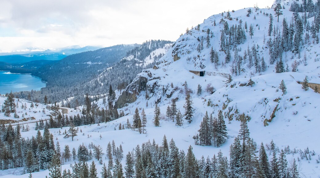 The Donner lake under the snow in winter, in California, panorama, with tunnels in the mountain for the train