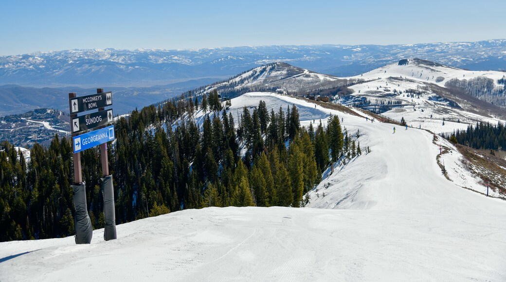 Trail sign at Park City Ski Area, Utah. Top view to the valley with mountains range during early spring weather conditions.