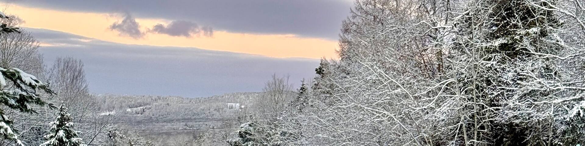 Route 23 leading to Windham Mountain in the distance. Scenic highway with gorgeous views of snowcapped mountain in the distance at sunrise in the early morning.