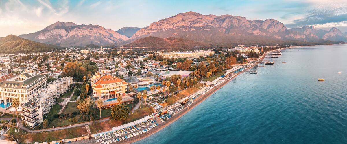 awe-inspiring aerial panorama of Kemer, Turkey, featuring luxurious hotels and majestic mountains in the backdrop.