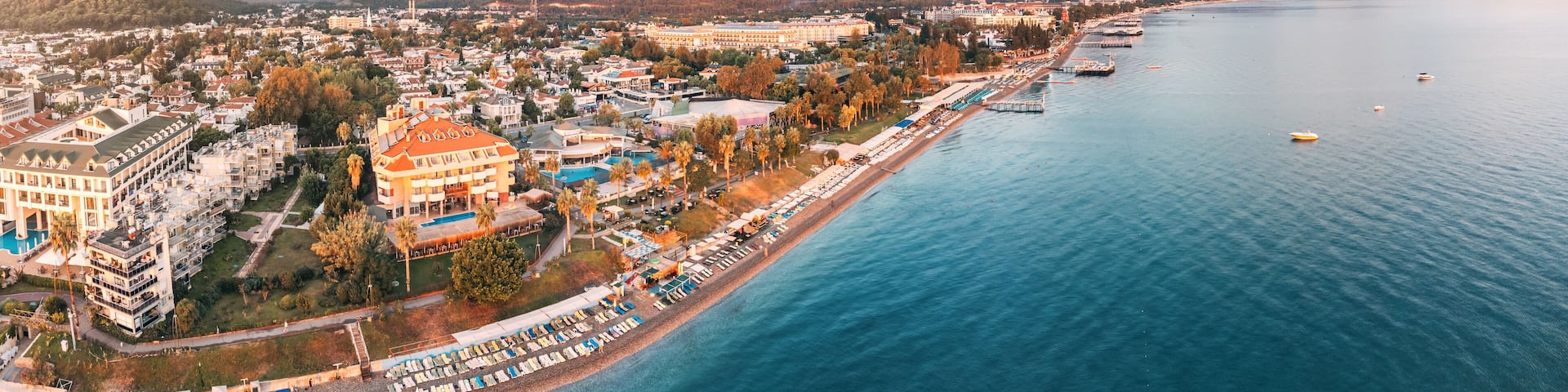 awe-inspiring aerial panorama of Kemer, Turkey, featuring luxurious hotels and majestic mountains in the backdrop.