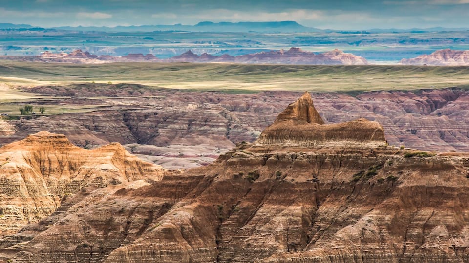 A rugged landscape with prominent buttes and rolling hills.