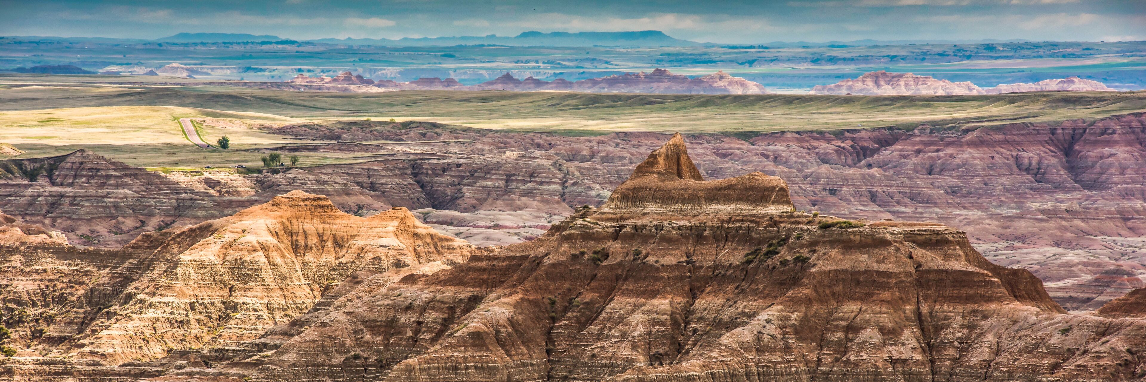 A rugged landscape with prominent buttes and rolling hills.