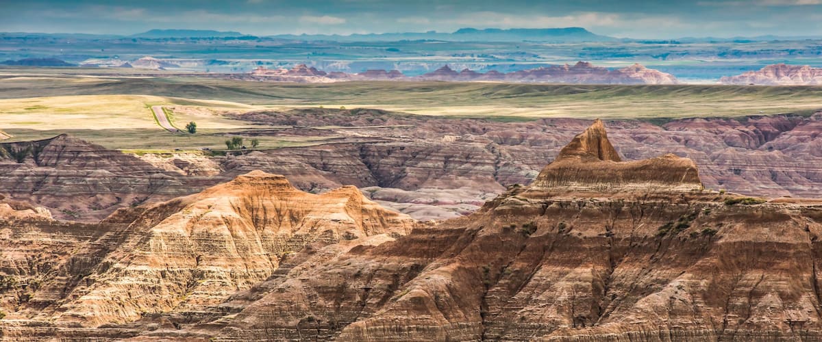 A rugged landscape with prominent buttes and rolling hills.