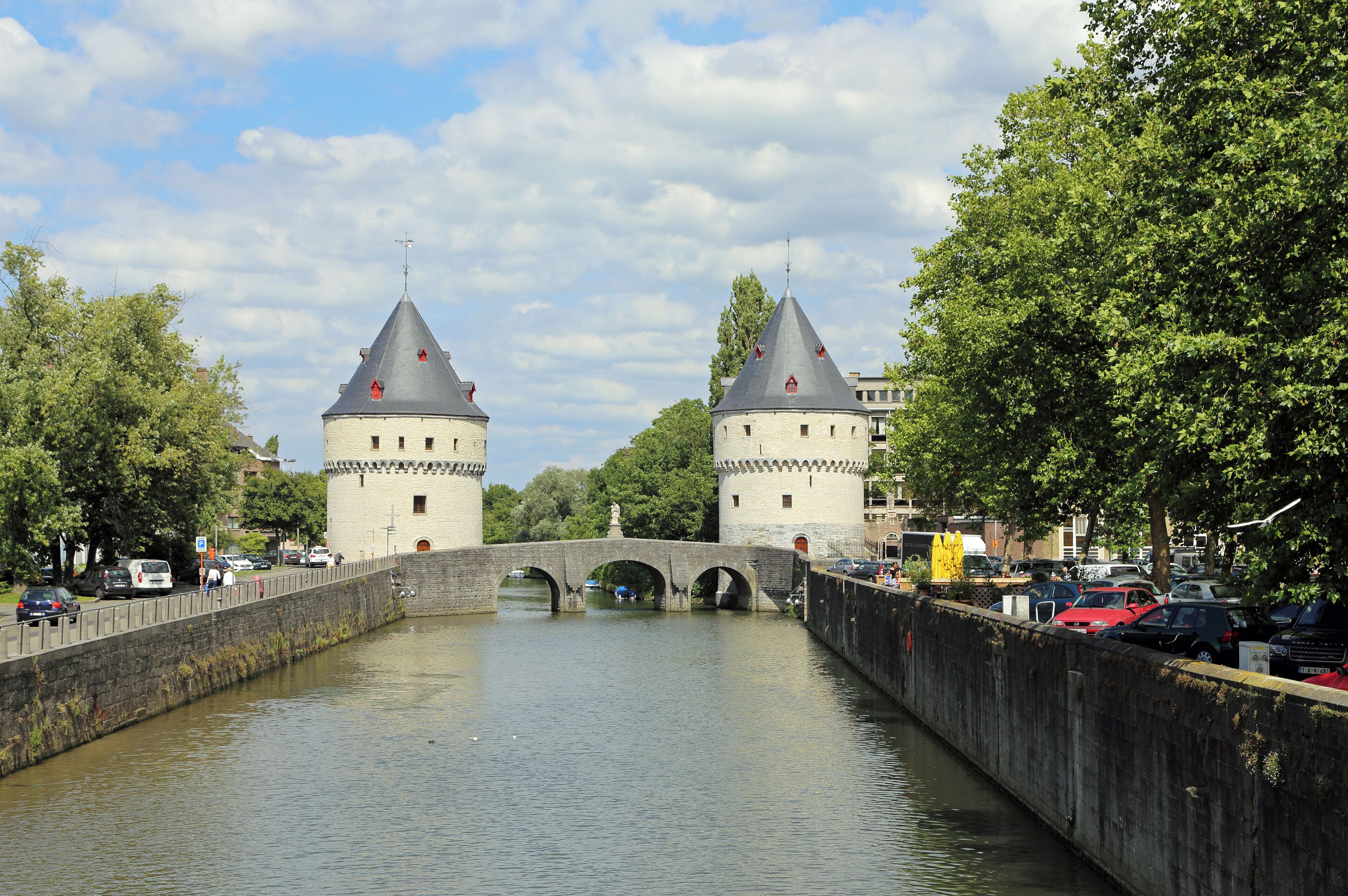 A historic stone bridge over a canal with two towers.