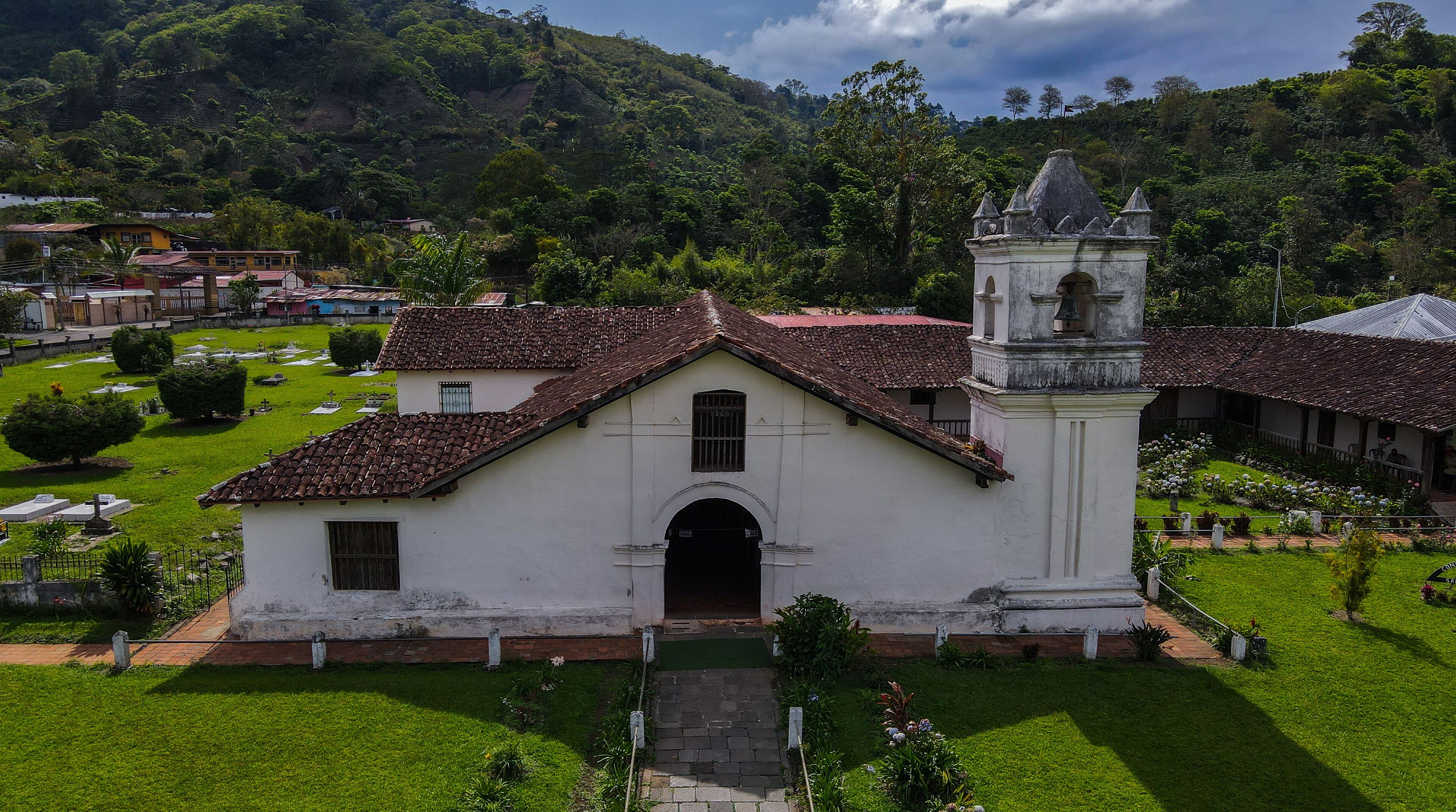 A white church with a bell tower and a cemetery.