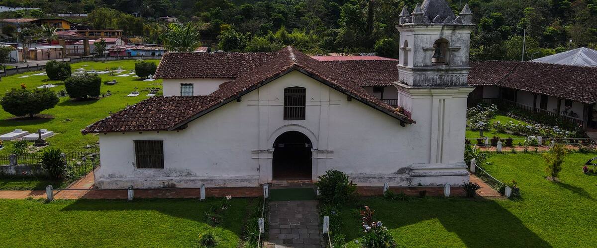 A white church with a bell tower and a cemetery.