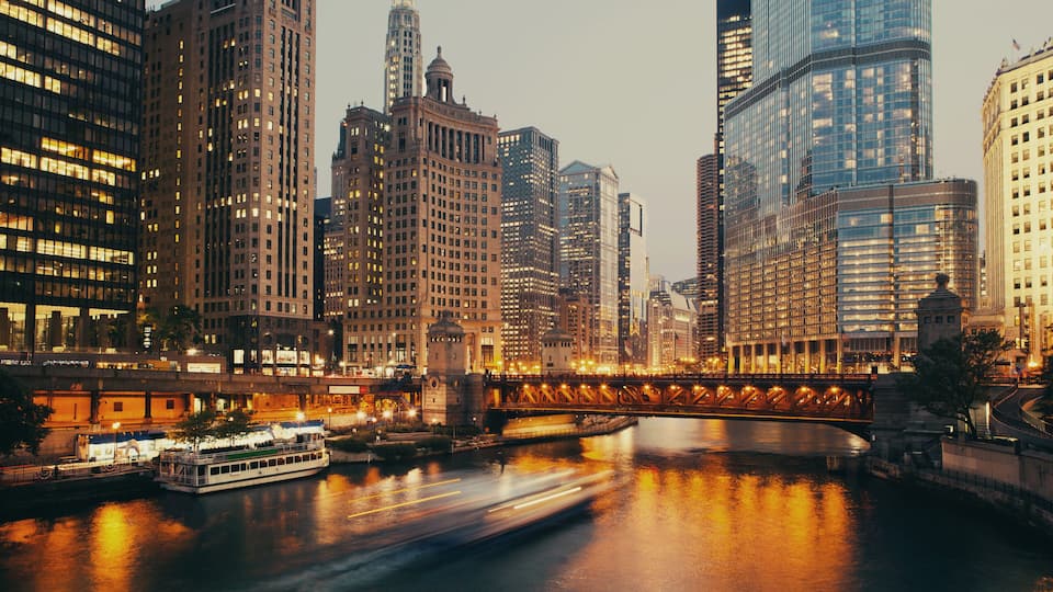 A cityscape with a river, a bridge, and high-rise buildings.
