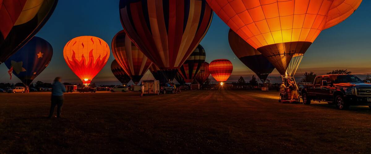 hot air balloons glowing in night sky