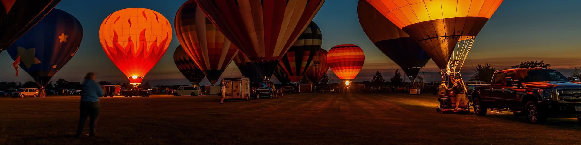 hot air balloons glowing in night sky