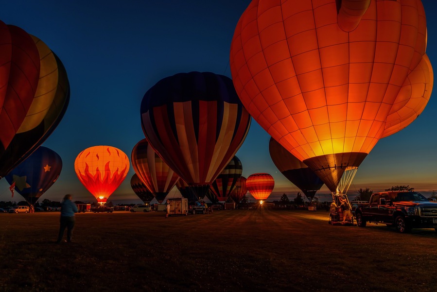 hot air balloons glowing in night sky
